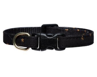May include: Black cat collar with a gold star pattern and a black plastic buckle.