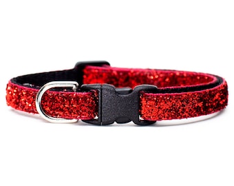 May include: A red glitter cat collar with a black buckle and silver D-ring.