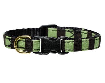 May include: A black and green striped cat collar with a gold metal buckle and a black plastic buckle.