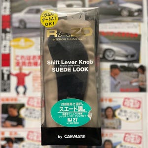 Peut inclure: Un pommeau de levier de vitesses noir avec un aspect suède, pour une utilisation avec des véhicules à transmission manuelle. L'emballage présente la marque "RAZO" et le texte "Shift Lever Knob Suede Look".