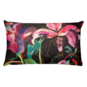 Puede incluir: Una almohada lumbar negra con un estampado floral colorido con flores rosas, rojas, moradas, verdes y doradas. Las flores son estilizadas y abstractas.