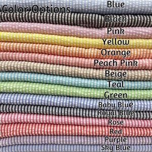 May include: A stack of seersucker fabric swatches featuring thin vertical stripes in various colors labeled Color Options: Blue, Black, Pink, Yellow, Orange, Peach Pink, Beige, Teal, Green, Baby Blue, Royal Blue, Rose, Red, Purple, and Sky Blue.