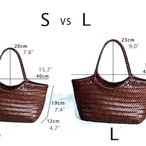 K&ouml;nnte beinhalten: Zwei geflochtene braune Leder-Tragetaschen, beschriftet mit S und L, mit Gr&ouml;&szlig;envergleichen. Die S-Tasche ist 19 cm hoch, 40 cm breit und 12 cm tief. Die L-Tasche ist 22 cm hoch, 42 cm breit und 12 cm tief.