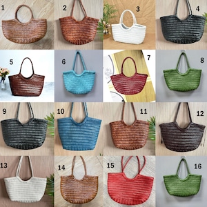 K&ouml;nnte beinhalten: Eine Sammlung von sechzehn gewebten Tragetaschen in verschiedenen Farben. Die Taschen haben eine abgerundete Form mit einem Griff. Zu den Farben geh&ouml;ren Braun, Rot, Schwarz, Blau, Gr&uuml;n und Wei&szlig;. Die Taschen sind von 1 bis 16 nummeriert.