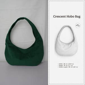 Könnte beinhalten: Dunkelgrüne Crescent Hobo Bag mit gebogenem Griff. Die Tasche ist 35 cm breit, 18 cm hoch und hat einen 56 cm langen Griff. Das Design der Tasche wird in einer weißen Illustration gezeigt.