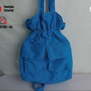 May include: A vibrant blue backpack featuring two front pockets and adjustable straps. The top of the bag has a drawstring closure. The image also includes text that says "Youtube Tutorial" and "US_LETTER + A4".