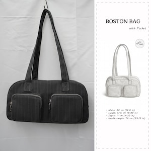 Può includere: Borsa Boston nera con due tasche frontali e un design a gessato. La borsa ha una lunghezza del manico di 74 cm, una larghezza di 32 cm, un'altezza di 17,5 cm e una profondità di 11 cm. Il testo "BOSTON BAG with Pocket" è visibile.