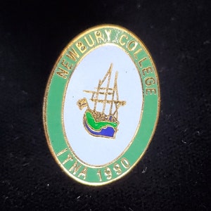 May include: Oval-shaped Newbury College pin with a gold border. The pin features a white center with a ship illustration, surrounded by a green border with the words "NEWBURY COLLEGE" and "LYNA 1980".