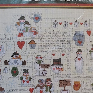 May include: A counted cross-stitch kit featuring a "Snow Buddies" folk art sampler. The design includes various snowmen, hearts, and the text "Snow Ice Cream." Finished size is 18" x 13" (45.7 x 33.0 cm).