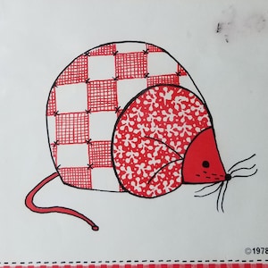 May include: A packaged craft pattern for a tea cozy. The design features a red and white checkered mouse with a red nose and tail. The text "Mousey Tea Cozy" is at the top, with the maker's information and copyright notice at the bottom.