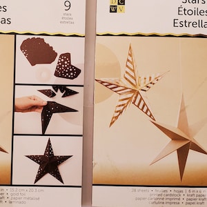 May include: Two DIY Project Stack kits for making star decorations. Each kit includes 28 sheets of printed cardstock and kraft paper. The packaging features the text "Stars" in English, French, and Spanish, with dimensions of 6 in x 8 in (15.2 cm x 20.3 cm).