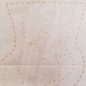 May include: Off-white fabric with a printed Christmas stocking pattern and the words "K HOLIDAY STOCK". The design includes dotted lines for cutting and sewing instructions, with additional text for notions and instructions.