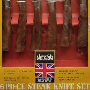May include: A six-piece steak knife set in a yellow box. The knives have brown handles and silver blades with a serrated edge. The box has text that reads "Sheffield Stainless Blades" and "Made in Great Britain."