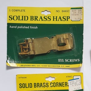 May include: A collection of solid brass hardware, including a hasp, corner pieces, hinges, and a bar window lift. The items are packaged on green and red cards with the words "Solid Brass" and "Hand Polished". Screws are included.