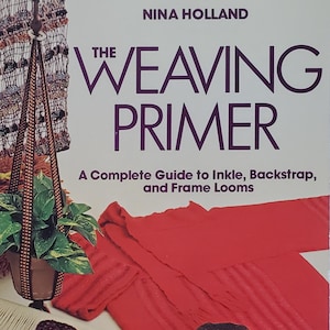 May include: A softcover book titled The Weaving Primer by Nina Holland, featuring a cover image of various woven textiles, a wooden loom, yarn balls, and a potted plant in a macrame hanger, with the subtitle A Complete Guide to Inkle, Backstrap, and Frame Looms.