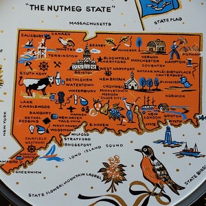 May include: A vintage metal serving tray featuring a map of Connecticut, with illustrations of landmarks and the state flag. The tray has a black border with gold stars and a gold rim. The state motto and state bird are also displayed.