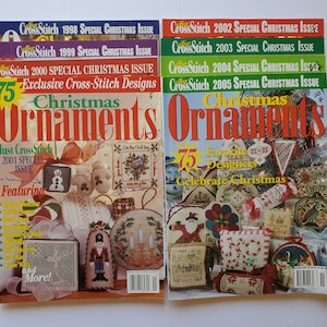 May include: A collection of eight Just CrossStitch magazines featuring Special Christmas Issues from 1998 through 2005. Each magazine cover displays various cross-stitch ornament designs, festive text, and holiday-themed imagery in vibrant colors.