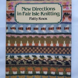 May include: A book titled "New Directions in Fair Isle Knitting" by Patty Knox. The cover features a colorful, patterned design in shades of blue, green, brown, orange, and pink, resembling knitted fabric. The title is in a white font within a green-bordered frame.