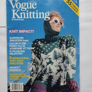 May include: A Fall/Winter 1985 issue of Vogue Knitting International magazine featuring a cover with a person wearing a green and white patterned knit sweater and hood, white sunglasses, and purple gloves, with text including Knit Impact.