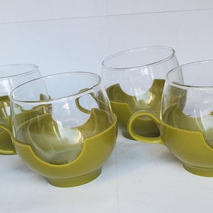 May include: A set of three ceramic mugs with a speckled, matte finish. Each mug features a different color: light blue, cream, and gray. The mugs have a simple, modern design with a rounded shape and a handle.