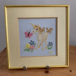 Gerahmtes Einhorn Kreuzstichmuster – Vintage Pastell Nadelspitzen-Stickerei mit Schmetterling & Blumen – Gesticktes, skurriles Dekor
