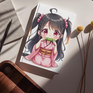 K&ouml;nnte beinhalten: Ein wei&szlig;es Notizbuch mit einer Anime-Illustration eines M&auml;dchens in einem rosa Kimono, das ein Bambusrohr h&auml;lt. Das M&auml;dchen hat schwarze Haare, rosa Augen und sitzt. Das Notizbuch liegt auf einer wei&szlig;en Oberfl&auml;che mit einem Bleistift und einem Holztablett.