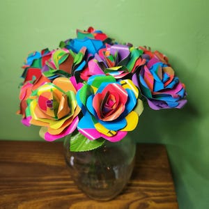Une douzaine de roses en papier, un bouquet de livres colorés pour un cadeau d'anniversaire ou des fleurs de rétablissement pour un lecteur ou un enseignant, fabriquées à la main à partir de pages de livres d'images