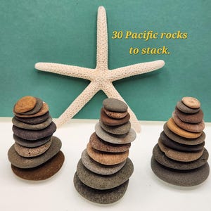 May include: Three stacks of smooth, colorful Pacific rocks, with a white starfish in the background. The rocks are various shades of brown, gray, and tan. Text reads: "30 Pacific rocks to stack."