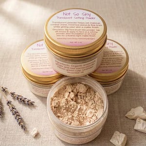 May include: Three round jars of Not So Shy Translucent Setting Powder with gold lids, each containing 1 oz of product. The labels list ingredients including organic arrowroot, raw cocoa powder, French green clay, and lavender essential oil.