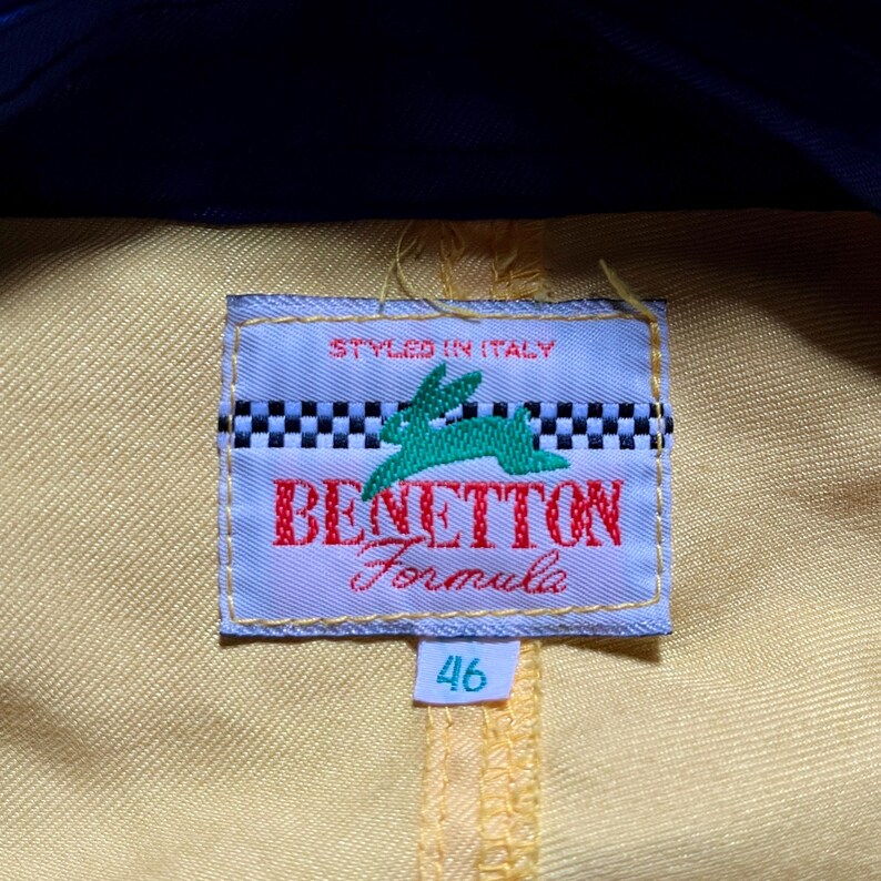 May include: A yellow and white label with the text "Benetton Formula" and a green rabbit logo. The label also says "Styled in Italy" and has a size tag that says "46".