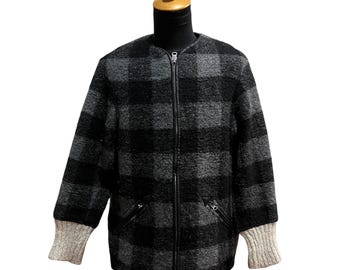 May include: A black and gray plaid jacket with a full-length zipper and two small front pockets. The jacket has light gray knit cuffs and is displayed on a mannequin.