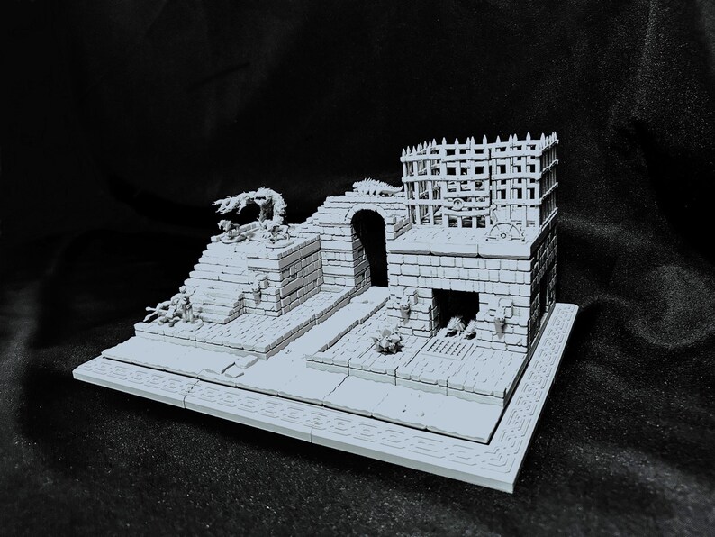 Puede incluir: Una maqueta gris de una fortaleza con un dise&ntilde;o de varios niveles. El modelo presenta un arco central, una torre con una parte superior enrejada y un trabajo de ladrillo detallado. Peque&ntilde;os elementos decorativos y una base con un borde estampado completan la escena.