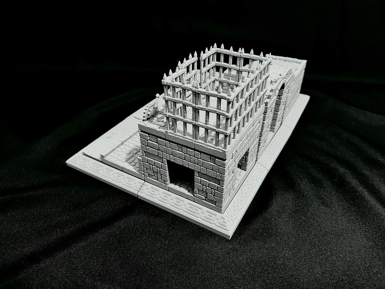 Puede incluir: Modelo en miniatura gris de un edificio con textura de piedra. La estructura presenta una base rectangular, una fachada detallada con puertas arqueadas y una estructura en forma de jaula en el tejado. Modelo para juegos de mesa o exhibici&oacute;n.