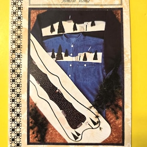 May include: A sewing pattern titled "Almost Home" with the text "Sew Mini Pieces." The pattern features a denim shirt design with tree appliqués and a black shirt design. The T-shirt appliqué is approximately 8 1/2" x 11".