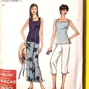 May include: A Simplicity sewing pattern envelope 9179 for sizes XS, S, M, L, XL. The cover features illustrations of two outfits: a solid navy tank top with a floral print maxi skirt, and a striped tank top with solid white cropped pants.