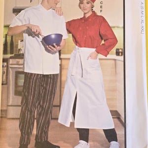 May include: McCall's sewing pattern featuring chef attire. The pattern includes a chef's jacket, pants, apron, and hat. The image shows a man and woman wearing the chef's uniform. The pattern is designed and printed in the USA.