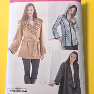 May include: Simplicity sewing pattern 2208 featuring three coat designs. The pattern includes sizes XS to XL. The image shows a tan coat with a textured collar, a blue polka-dot hooded jacket, and a gray coat with decorative trim.
