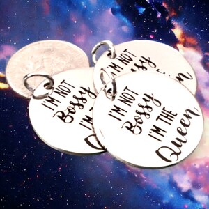 May include: Four silver charm pendants with the text "I'm not bossy, I'm the queen" on one of the pendants.