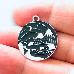 May include: A silver charm with a black and white enamel design of a mountain range under a starry night sky. The charm features a crescent moon, stars, and a small tent.