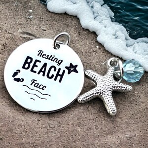 May include: Silver charm with a round disc that says "Resting Beach Face" with a small starfish and a blue crystal charm.