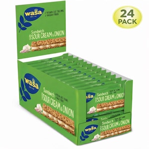Può includere: Una scatola espositiva verde con panini Wasa Sour Cream & Onion. La scatola ha la scritta "24 PACK" e "VEGAN OAT FILLING / HIGH FIBER". Il logo Wasa è visibile.