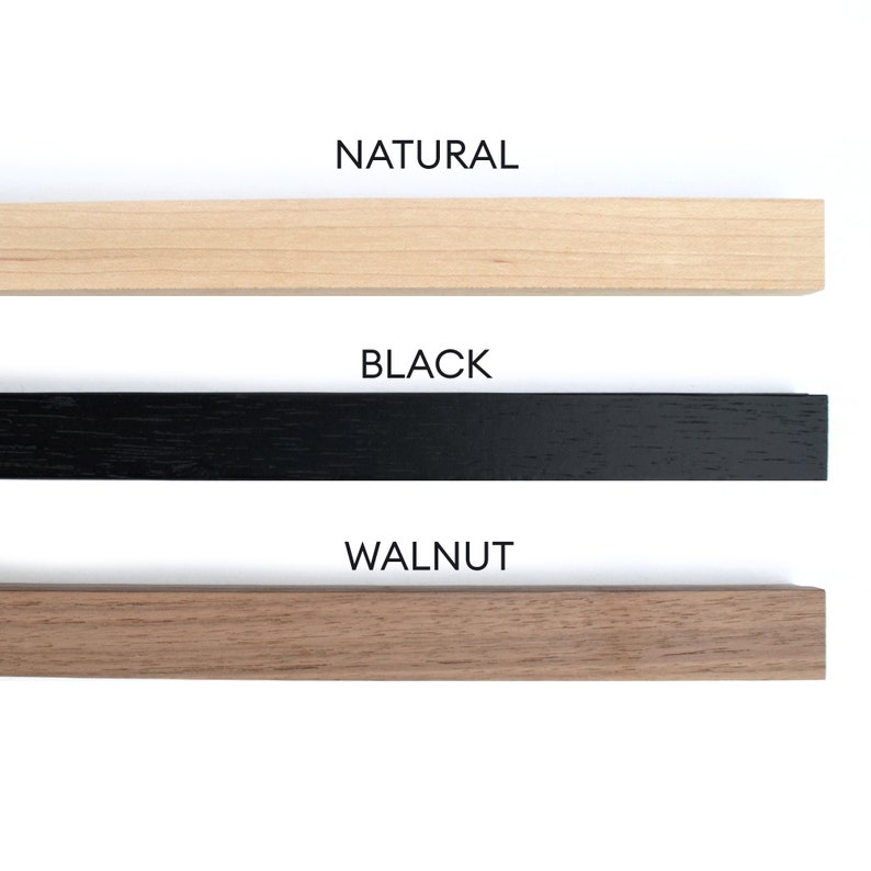 May include: Three wooden samples in natural, black, and walnut finishes. The samples are arranged vertically with the natural finish at the top, followed by the black finish, and the walnut finish at the bottom. The text "NATURAL", "BLACK", and "WALNUT" is printed below each sample.