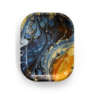 May include: Rectangular tray with rounded corners, featuring a swirling abstract design. The pattern incorporates shades of blue, yellow, and brown, creating a marbled effect. The tray has a glossy finish and a dark border.