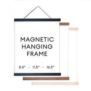 May include: A black magnetic hanging frame with a white background. The frame is 8.5 inches by 11.5 inches by 16.5 inches. The text "MAGNETIC HANGING FRAME" is printed on the white background.