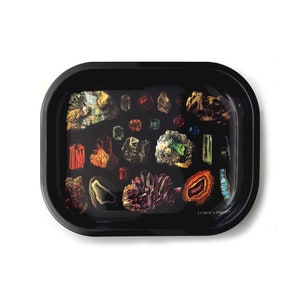 May include: Black tray with a colorful print of various gemstones and the text "Curious Goods".