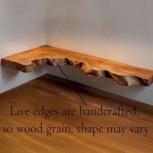 Op de afbeelding: Houten hoekplank met een natuurlijke rand, met natuurlijke houtnerf. De plank heeft een warme bruine tint en een kenmerkende, organische vorm. De tekst op de afbeelding luidt: "Levende randen zijn handgemaakt, dus houtnerf, vorm kan vari&euml;ren."