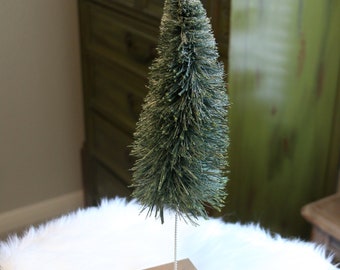 14" roughly distressed and faded forest green bottle brush tree on large bronze block.