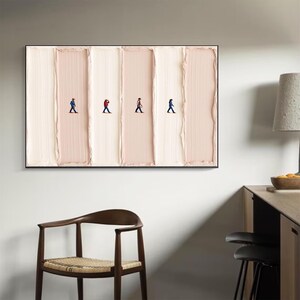 May include: Abstract wall art featuring four figures walking across a textured, vertical background of alternating light and medium beige tones. The figures are dressed in various colors, adding a pop of contrast to the neutral palette.