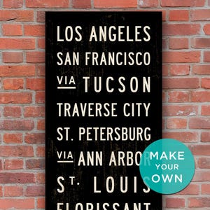 Può includere: Un cartello rettangolare nero con testo bianco che elenca le città di Los Angeles, San Francisco, Tucson, Traverse City, St. Petersburg, Ann Arbor, St. Louis, Florissant, Pasadena e Sierra Madre, con un cerchio turchese Make Your Own.
