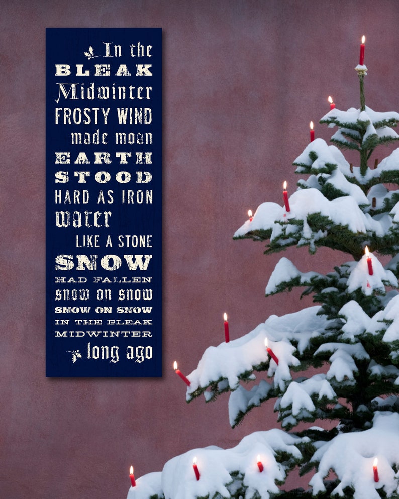 May include: A navy blue rectangular sign with white text, including the words "In the Bleak Midwinter." A snow-covered Christmas tree with lit red candles is on the right. The background is a muted red.